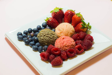 Set of ice cream scoops of different colors and flavours with fruits decoration isolated on white background 