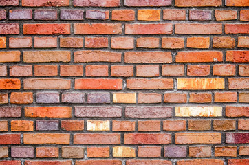 Recently built masonry wall with deep joints and a colorful blend of traditional looking bricks