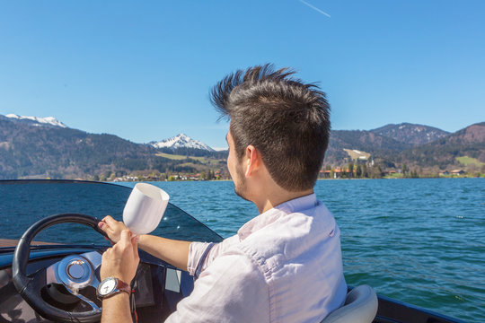 Young guy in charge of baot looks a the scenery