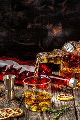 pouring whiskey into Glass on wooden surface. concept luxury drink