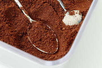 Ground coffee in spoon, natural coffee background, macro