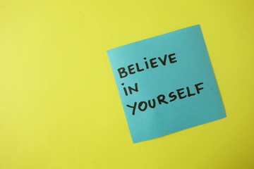Believe in yourself written on blue sticky note, motivation concept