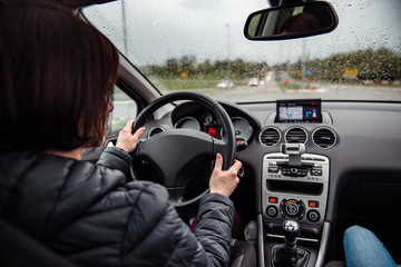 Woman driving car on a rainy day