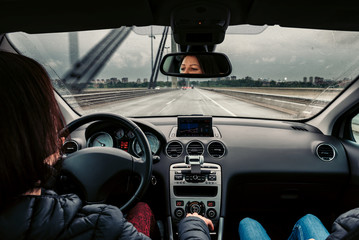 Woman driving car over the bridge