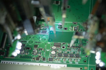 Obraz premium Factory for the production of microchips. CNC machine with needles solders the microchip to the motherboard. New technologies in electronics. Automatic robot prints microchip or electronic board
