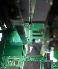 Factory for the production of microchips. CNC machine with needles solders the microchip to the motherboard. New technologies in electronics. Automatic robot prints microchip or electronic board