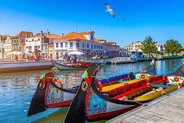 Fotobehang Traditionele boten op het kanaal in Aveiro, Portugal. Kleurrijke Moliceiro-boottochten in Aveiro zijn populair bij toeristen om te genieten van het uitzicht op de charmante grachten. Aveiro, Portugal. © daliu