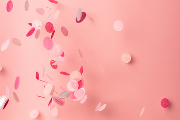 Pink confetti on pink background. Copyspace for text. Bright and festive holiday background. - obrazy, fototapety, plakaty