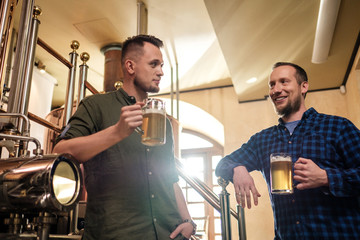 Two men tasting fresh beer in a brewery