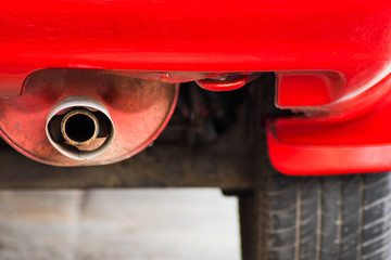 Selective focus of close up exhaust pipe of the red car
