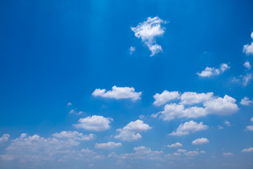 Fuffy clouds on bright blue sky background.