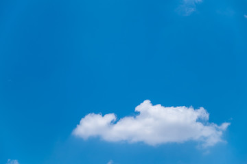 Fuffy clouds on bright blue sky background.