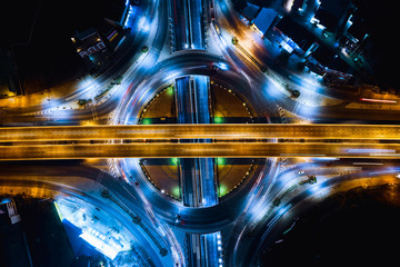 long exposure night traffic head light car on the ring road and freeways overpass intersection connecting the city transportation logistics business in Thailand