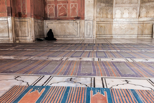 ein betender Mensch vor einer Moschee