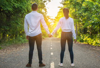 Couple walking hand in forest road