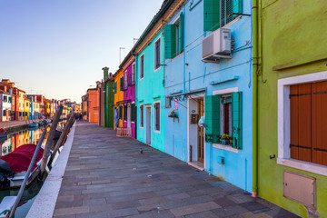 Naklejka premium Ulica z kolorowymi budynkami na wyspie Burano, Wenecja, Włochy. Architektura i zabytki Burano w Wenecji. Malowniczy kanał i kolorowa architektura na wyspie Burano w pobliżu Wenecji, Włochy