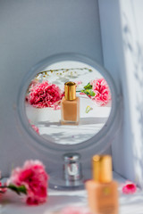 Perfume bottle with mirror and dianthus flowers