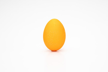 Ein Osterei, orange vor weißem HIntergrund