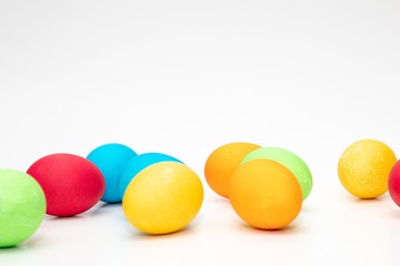 Gefärbte Ostereier am unteren Rand vor weißem Hintergrund