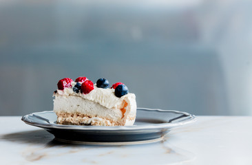 piece of cream pie with blueberries and raspberries on a table