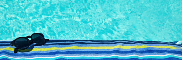 Swimming pool, sunglasses and bath towel with copy space, summer concept