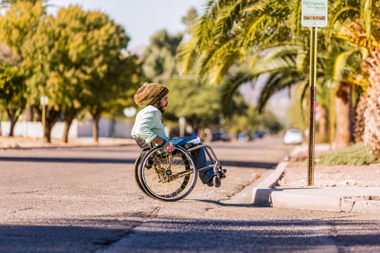 Man In Wheelchair Approaching City Curb