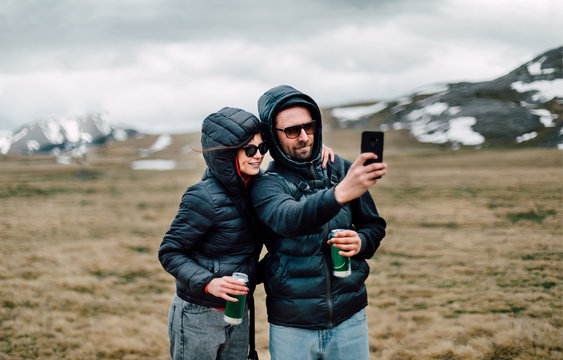 Young couple taking selfie photo at a mountaintop