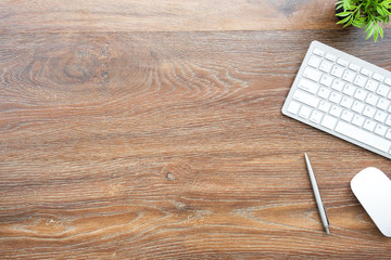 Wood office desk table with computer mouse, keyboard and supplies. Top view with copy space, flat...