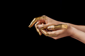 cropped view of female hands painted in golden isolated on black