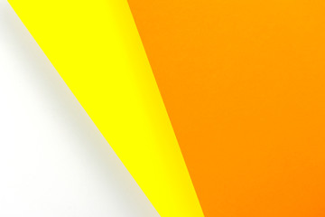 Colored sheets of paper lying on top of each other. The paper is orange and yellow