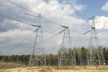 Pylons of high-voltage power lines and a blue sky with clouds.