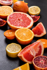 Naklejka na ściany i meble Close up, macro. Colorful slices juicy citrus fruits on a black background.