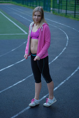 Obraz premium Beautiful blond girl with fit body posing for photo at sports playground