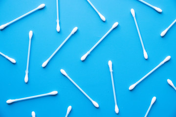 Flat lay composition with cotton swabs on blue background. Top view ear sticks