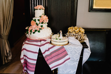 A delicious sweet wedding loaf in the Ukrainian style on embroidered towels. Festive sweet table.