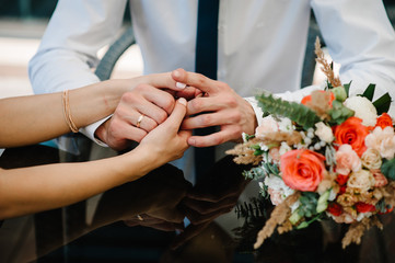 Obraz na płótnie Canvas The Bride and groom holding hands. Stylish wedding bouquet of flowers.