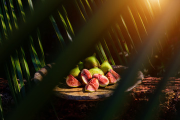 Figs among the leaves. Creative photography of tropical fruit in beautiful processing.