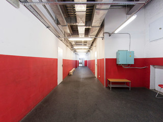 Long corridor, red white walls, doors, rubber floor for skates