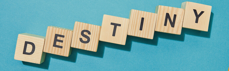 panoramic shot of wooden cubes with letters on blue surface