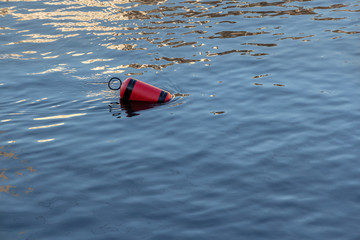  Single red mooring buoy on calm sea water