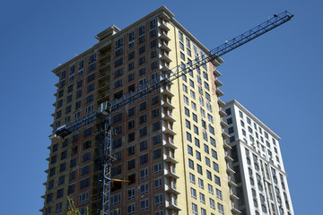 Fototapeta na wymiar Constructing high rise building with crane