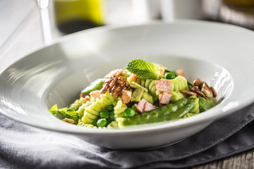 Fusilli pasta with green peas ham and walnuts. italian or mediterranean cuisine