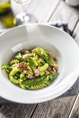 Fusilli pasta with green peas ham and walnuts. italian or mediterranean cuisine