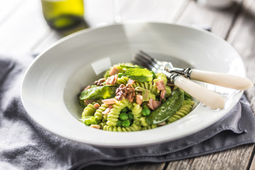 Fusilli pasta with green peas ham and walnuts. italian or mediterranean cuisine