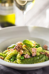 Fusilli pasta with green peas ham and walnuts. italian or mediterranean cuisine