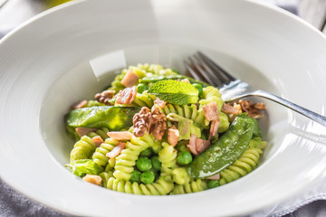 Fusilli pasta with green peas ham and walnuts. italian or mediterranean cuisine