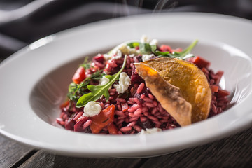 Beetroot risotto with feta cheese potato chips arugula and olive oil