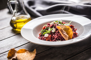 Beetroot risotto with feta cheese potato chips arugula and olive oil