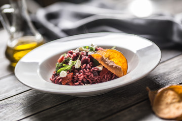 Beetroot risotto with feta cheese potato chips arugula and olive oil