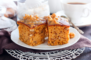 Homemade pie with nuts and raisins boiled condensed milk on a white plate, cut into squares, horizontal